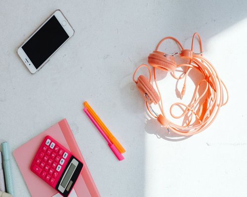 phone headphones and notebook on a work desk